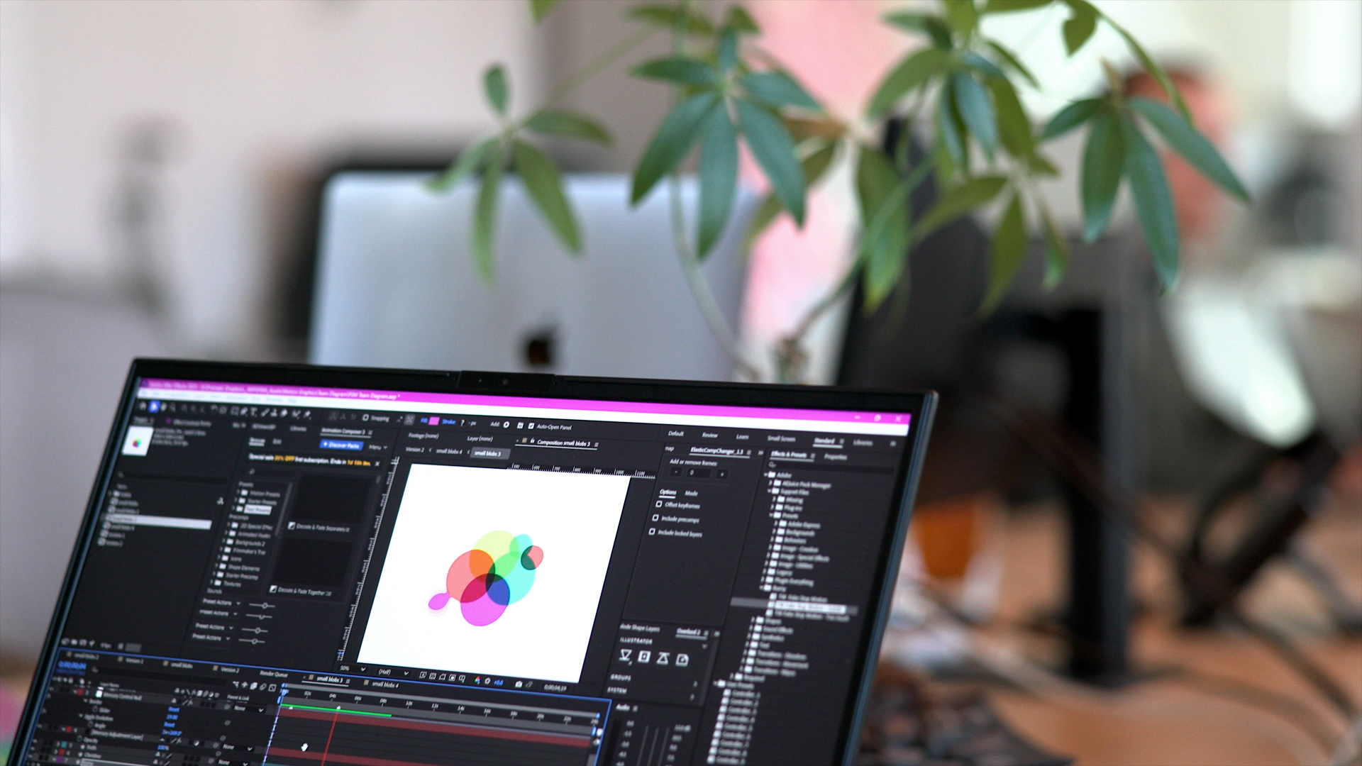 A laptop screen within an office setting showing a colorful venn diagram in an animation software program
